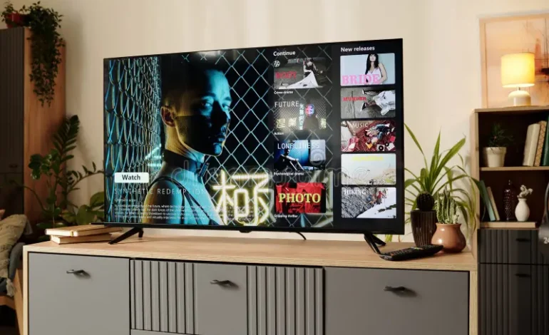 A large smart television mounted on a modern living room wall displaying a cinematic media streaming application interface.